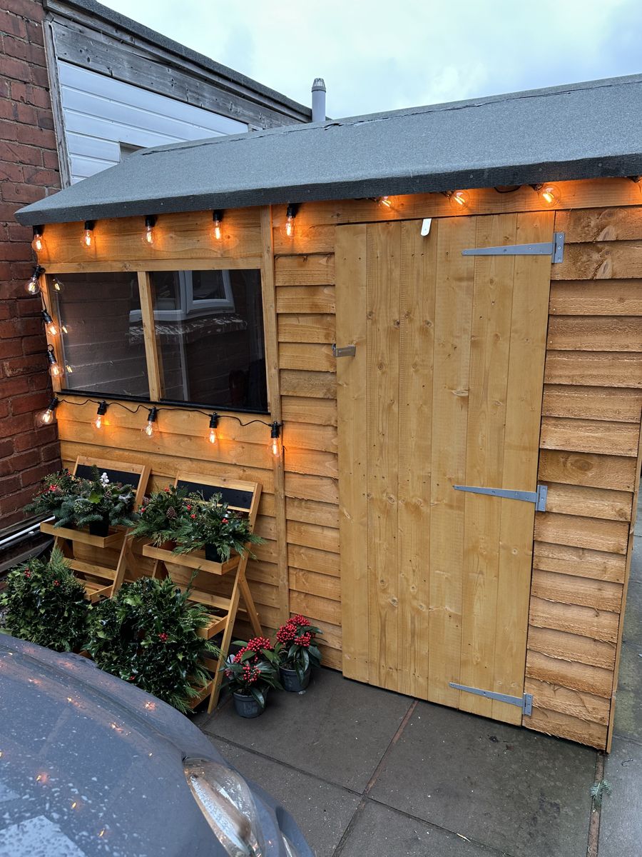 The Seasons Bloom garden workshop in Hammerwich, with festoon lights and plants outside